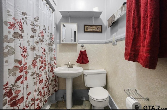 bathroom with sink, a shower with shower curtain, and toilet