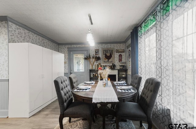 dining area featuring light hardwood / wood-style flooring and crown molding