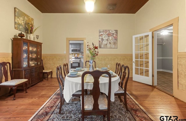 dining space with wood-type flooring and tile walls