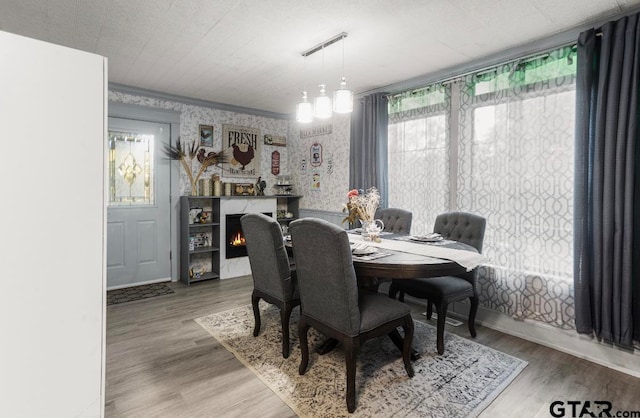 dining area with a chandelier, wood-type flooring, and crown molding