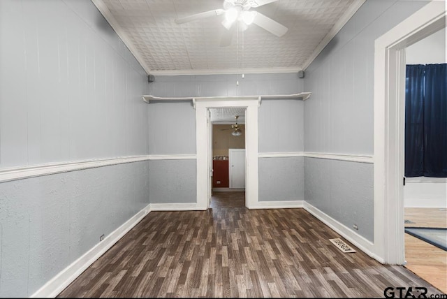 unfurnished room featuring wooden walls, dark hardwood / wood-style floors, ceiling fan, and ornamental molding