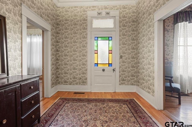 foyer with light hardwood / wood-style flooring and ornamental molding