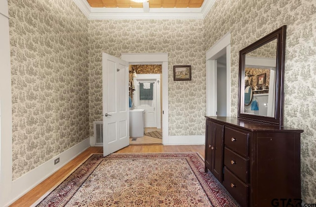 hall with ornamental molding and light wood-type flooring