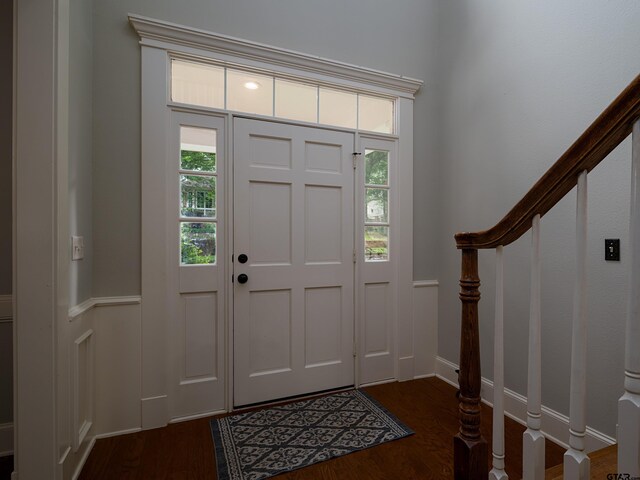entrance foyer featuring dark wood-type flooring, stairs, and baseboards