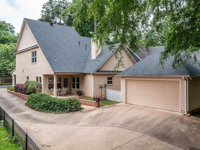 view of front of house featuring fence, roof with shingles, a garage, a chimney, and driveway