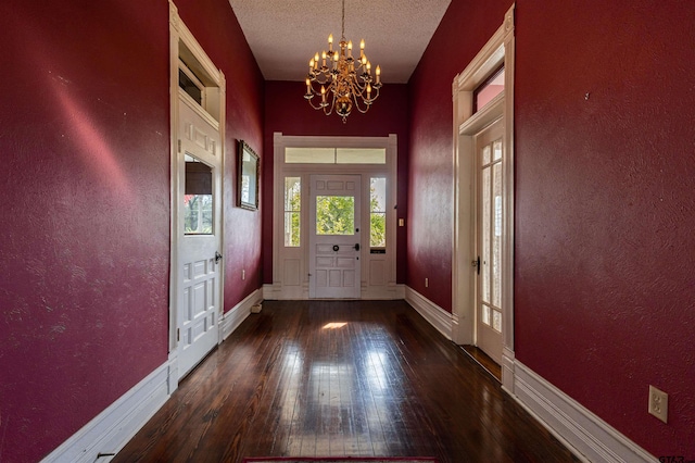 doorway to outside with a textured ceiling, dark hardwood / wood-style floors, and an inviting chandelier