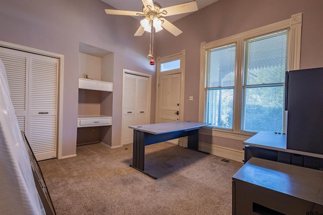 carpeted office with plenty of natural light and ceiling fan