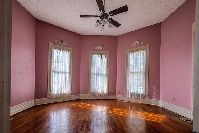 empty room with dark wood-type flooring, ceiling fan, a textured ceiling, and lofted ceiling