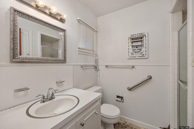 bathroom featuring vanity, a shower with door, toilet, and a textured ceiling