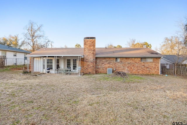 rear view of property with a lawn, a patio, and central air condition unit