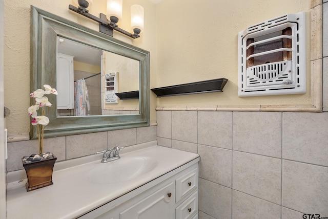 bathroom featuring vanity and tile walls