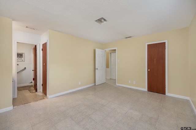 unfurnished bedroom with a textured ceiling