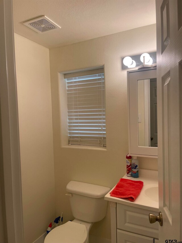 bathroom with vanity, a textured ceiling, and toilet