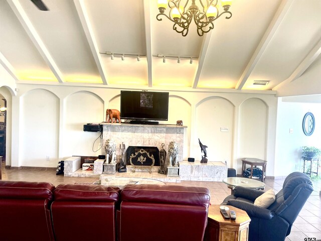 464 Forest Hills Dr, Livingston, TX 77351 - tiled living room with rail lighting, a premium fireplace, a chandelier, vaulted ceiling, and arched walkways