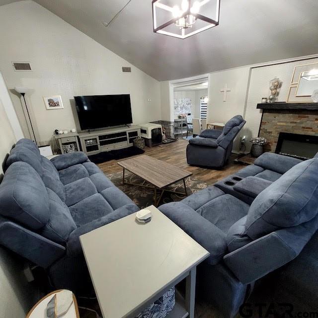 living room featuring hardwood / wood-style floors, a fireplace, and vaulted ceiling