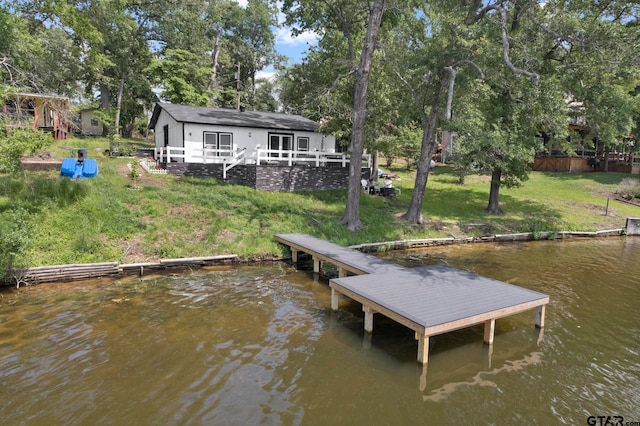 view of dock with a water view and a yard