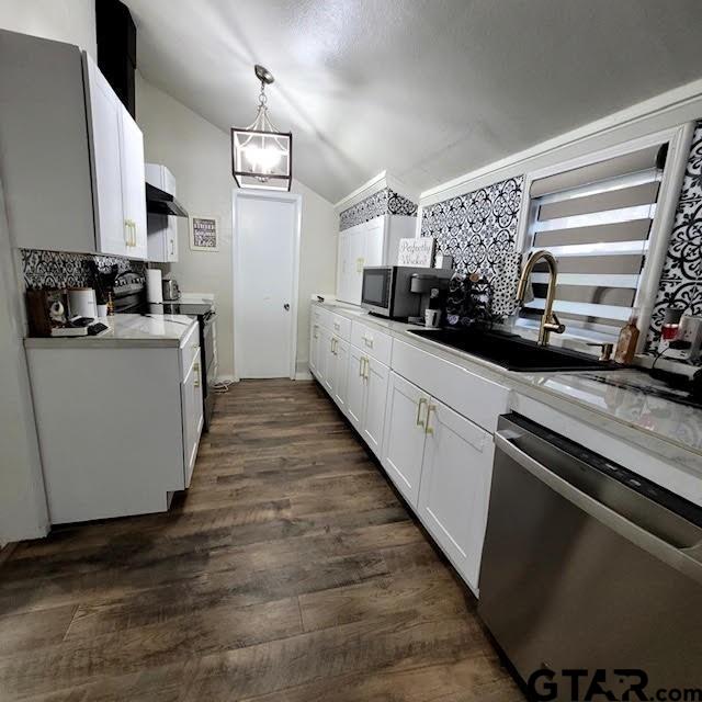 kitchen featuring stainless steel appliances, dark hardwood / wood-style flooring, hanging light fixtures, sink, and white cabinets