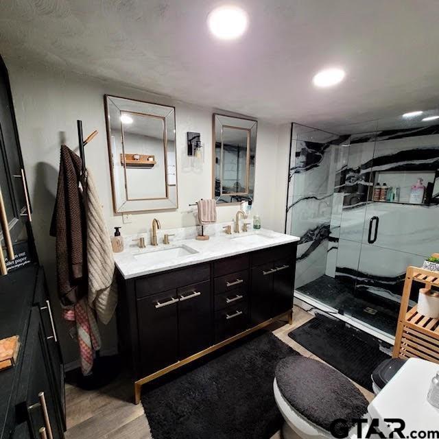 bathroom featuring vanity, hardwood / wood-style flooring, and a shower with shower door