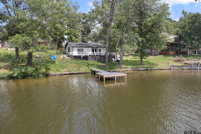 dock area with a water view and a yard