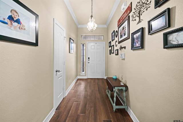 entryway with dark hardwood / wood-style flooring, a chandelier, and crown molding