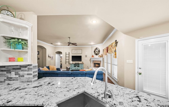 kitchen featuring ornamental molding, sink, ceiling fan, and light stone countertops