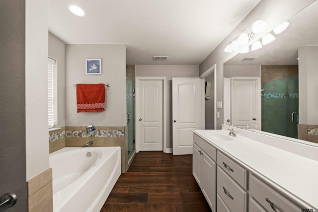 bathroom featuring hardwood / wood-style flooring, vanity, and independent shower and bath