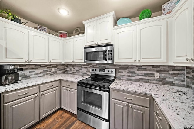 kitchen with gray cabinets, white cabinets, dark hardwood / wood-style floors, and stainless steel appliances