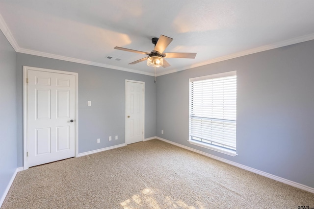 unfurnished bedroom with ornamental molding, ceiling fan, and carpet