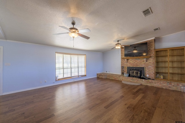 unfurnished living room featuring hardwood / wood-style floors, ceiling fan, ornamental molding, a wood stove, and a textured ceiling