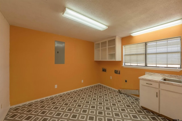 laundry area featuring sink, a textured ceiling, electric panel, cabinets, and hookup for an electric dryer