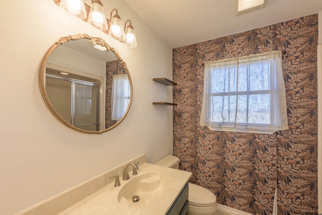 bathroom featuring toilet, an enclosed shower, and vanity