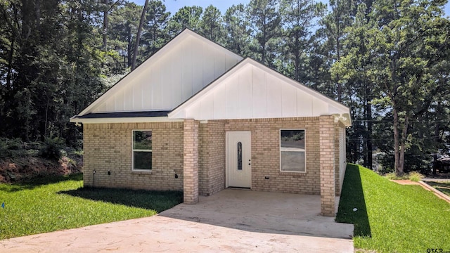 20428 High Point Dr, Flint, TX 75762 - view of front of house featuring brick siding, a front lawn, board and batten siding, and driveway