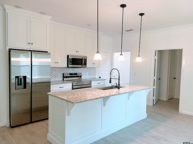 20428 High Point Dr, Flint, TX 75762 - kitchen with stainless steel appliances, white cabinetry, a kitchen breakfast bar, a kitchen island with sink, and decorative backsplash