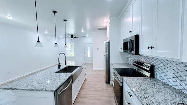 20428 High Point Dr, Flint, TX 75762 - kitchen featuring appliances with stainless steel finishes, tasteful backsplash, an island with sink, white cabinetry, and a ceiling fan