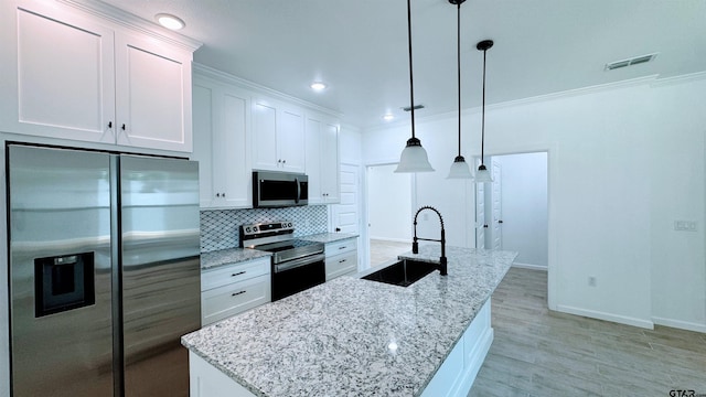 20428 High Point Dr, Flint, TX 75762 - kitchen featuring appliances with stainless steel finishes, tasteful backsplash, white cabinetry, an island with sink, and ornamental molding