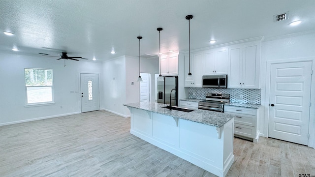 20428 High Point Dr, Flint, TX 75762 - kitchen featuring appliances with stainless steel finishes, tasteful backsplash, white cabinetry, a center island with sink, and recessed lighting