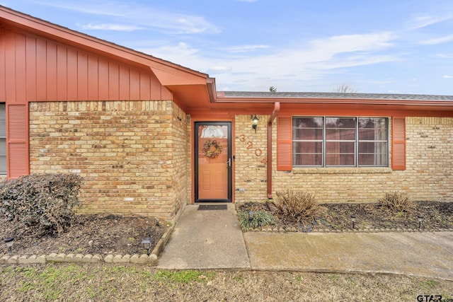 doorway to property with brick siding