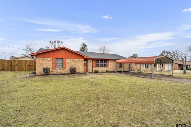 view of front of home with brick siding, fence, a front lawn, and a detached carport