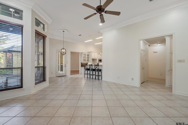 spare room with light tile patterned floors, ceiling fan, and crown molding