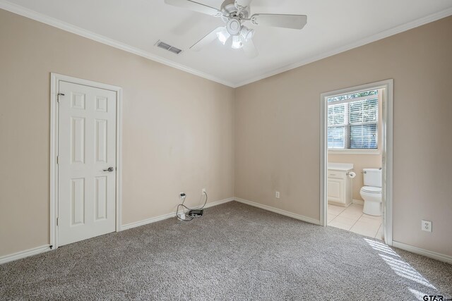 unfurnished bedroom with light carpet, ensuite bathroom, ceiling fan, and ornamental molding