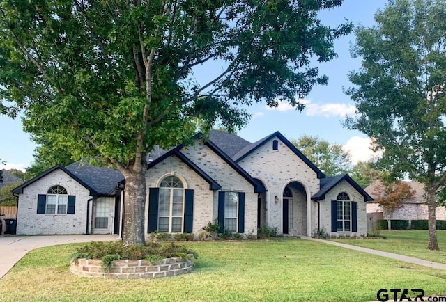 french provincial home with a front lawn