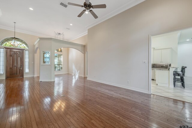 unfurnished living room featuring ceiling fan, light hardwood / wood-style flooring, and ornamental molding