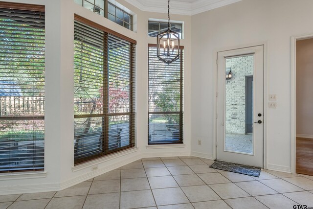 doorway to outside with a notable chandelier, light tile patterned flooring, and crown molding