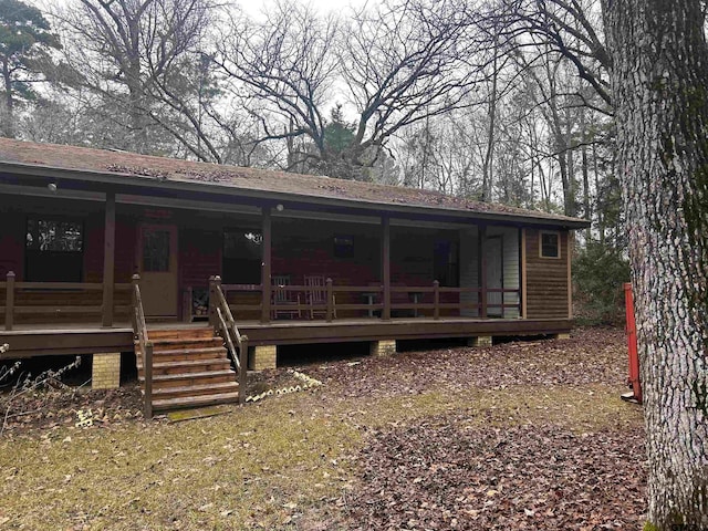 rear view of property with roof with shingles and a wooden deck