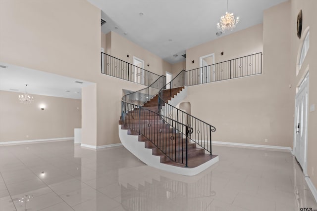 stairway featuring tile patterned flooring, a towering ceiling, and an inviting chandelier