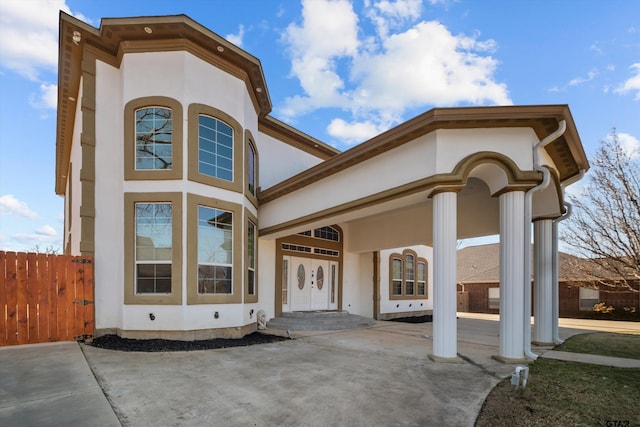 view of front of home featuring french doors, fence, and stucco siding