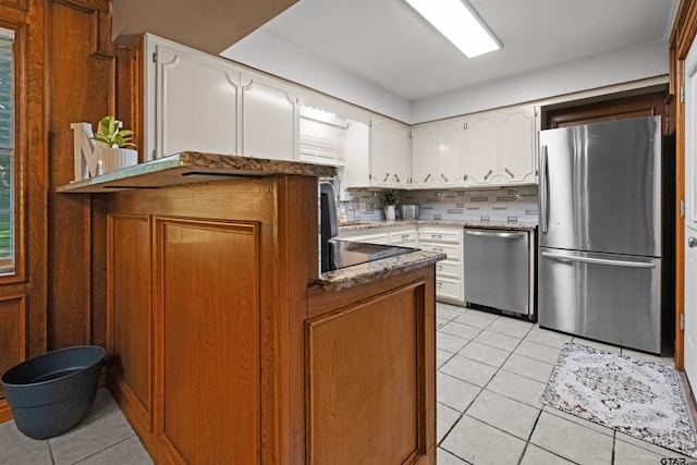 1330POWERS Drive Dr, Tyler, TX 75701 - kitchen featuring appliances with stainless steel finishes, light tile patterned floors, decorative backsplash, white cabinets, and light stone countertops