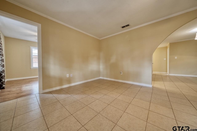 tiled spare room featuring crown molding