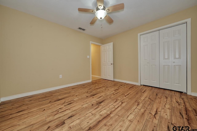 unfurnished bedroom with a closet, light hardwood / wood-style flooring, and ceiling fan