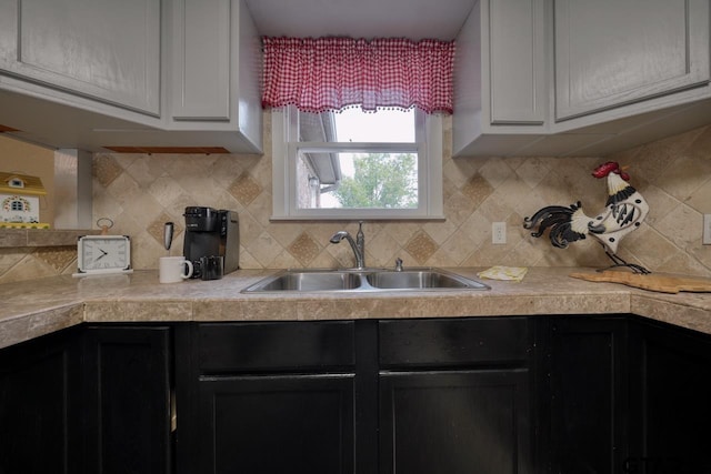 kitchen with tasteful backsplash, sink, and white cabinets